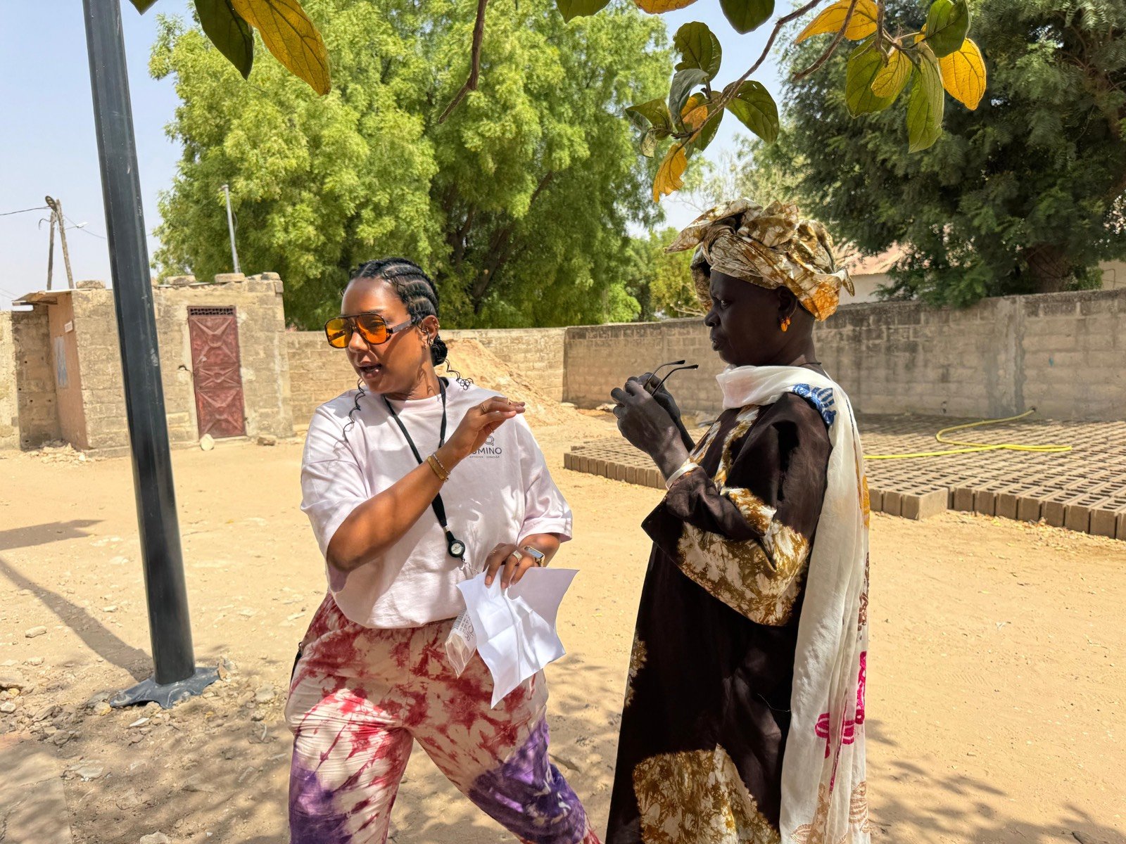 Une bénévole remet ses lunettes à une habitante lors d'une mission à Dakar